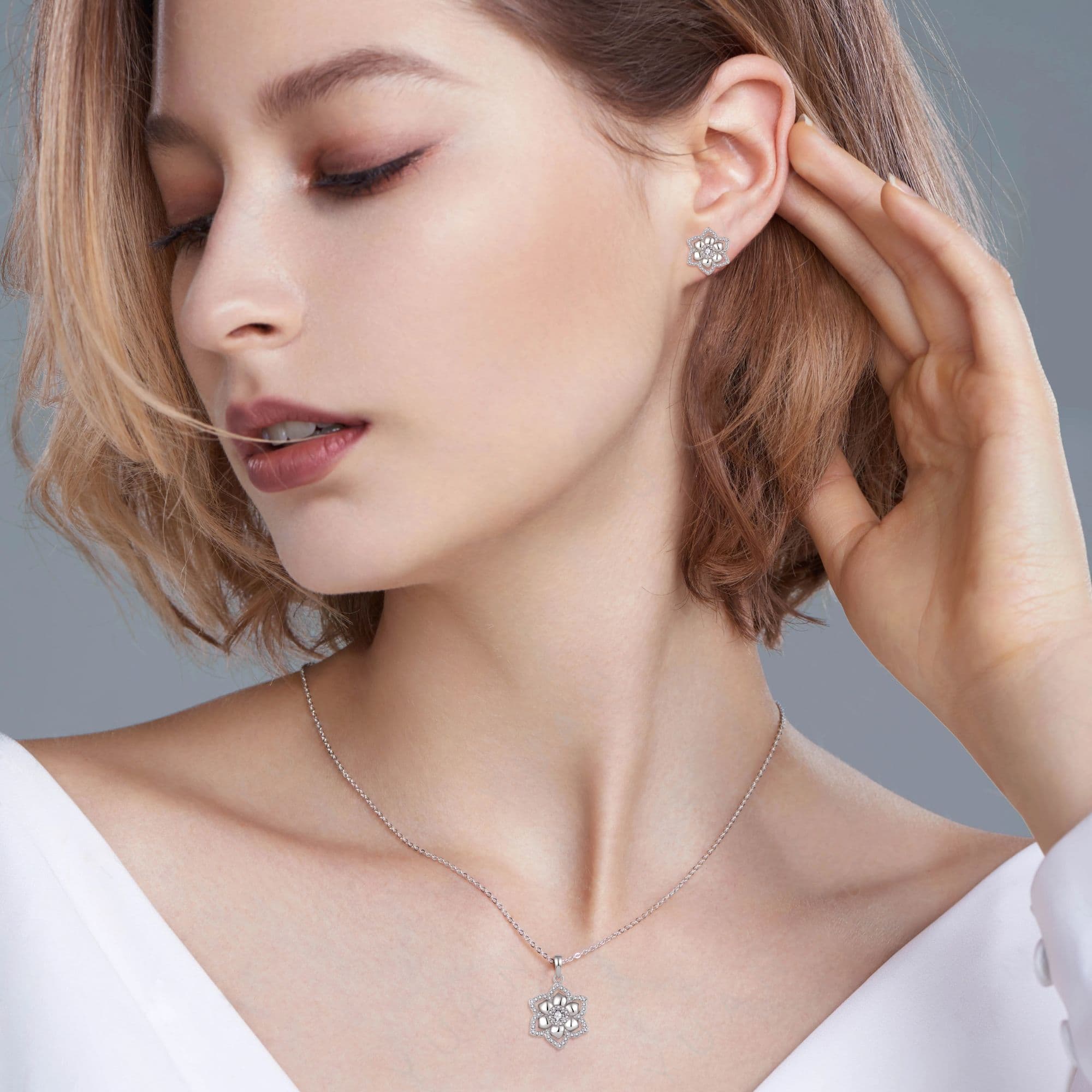 Model wearing a Marhabu moissanite lotus pendant and matching stud earrings in 925 sterling silver